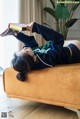 A woman laying on a couch reading a book.