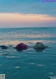 A woman floating in the ocean with her head above the water.