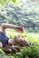 A woman laying in the grass with her eyes closed.